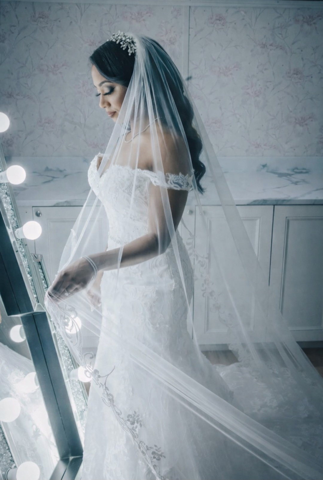 Bride adjusting her veil in a mirror after alterations