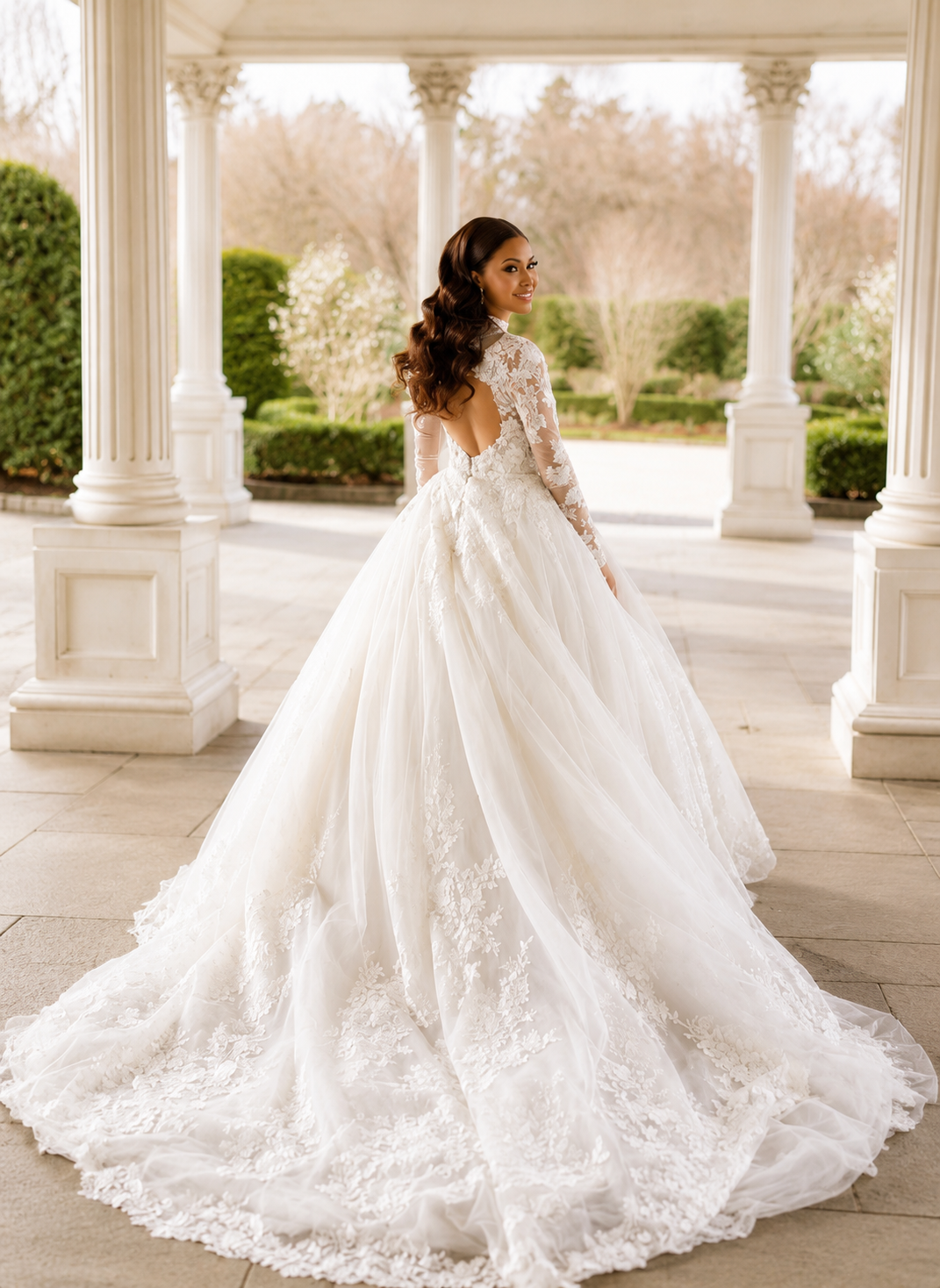 Bride in long-sleeve lace ballgown at garden portico